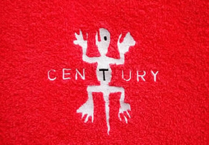 Close-up on a red, textured fabric featuring a white embroidered logo of a stylized figure with outstretched arms and legs, above the word "CENTURY" embroidered in white.